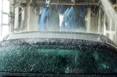 Oto yıkama, siyah arabaya otomatik oto yıkama, kırmızı ve mavi fırça döner. Yıkama araç.