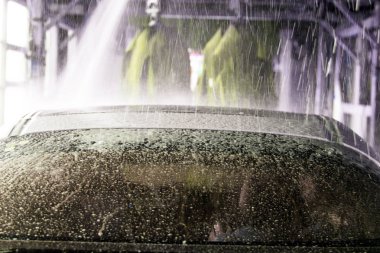 Oto yıkama, siyah arabaya otomatik oto yıkama, kırmızı ve mavi fırça döner. Yıkama araç.