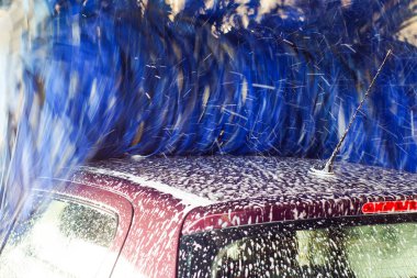 Oto yıkama, siyah arabaya otomatik oto yıkama, kırmızı ve mavi fırça döner. Yıkama araç.