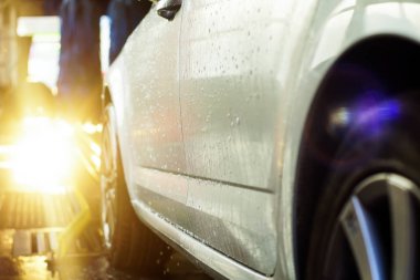 Oto yıkama, siyah arabaya otomatik oto yıkama, kırmızı ve mavi fırça döner. Yıkama araç.