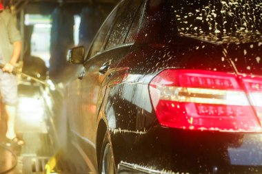 Oto yıkama, siyah arabaya otomatik oto yıkama, kırmızı ve mavi fırça döner. Yıkama araç.