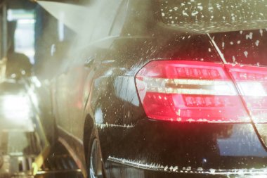 Oto yıkama, siyah arabaya otomatik oto yıkama, kırmızı ve mavi fırça döner. Yıkama araç.