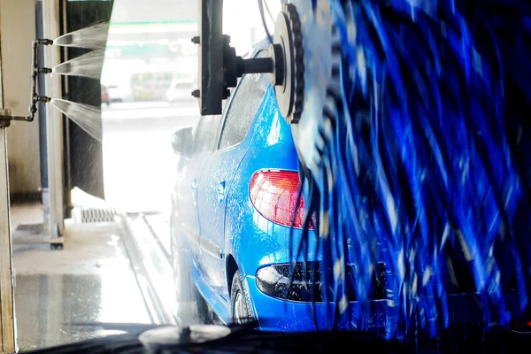 Oto yıkama, siyah arabaya otomatik oto yıkama, kırmızı ve mavi fırça döner. Yıkama araç.