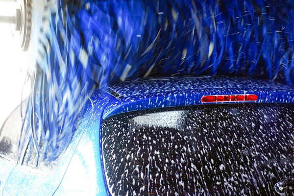 Oto yıkama, siyah arabaya otomatik oto yıkama, kırmızı ve mavi fırça döner. Yıkama araç.