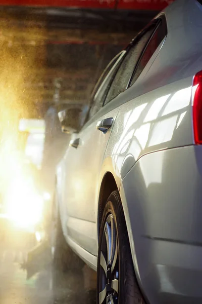 Car wash, zwarte auto in automatische Autowassen, roterende borstel van rood en blauw. Wassen voertuig. — Stockfoto