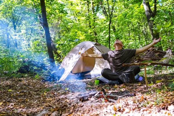 Bir şenlik ateşi ve ormandaki bir turist çadır, çadır turist dinleniyor.