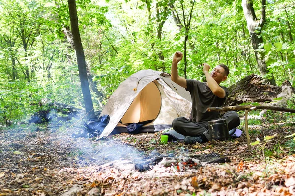 Bir şenlik ateşi ve ormandaki bir turist çadır, çadır turist dinleniyor.