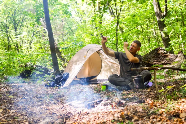 Bir şenlik ateşi ve ormandaki bir turist çadır, çadır turist dinleniyor.