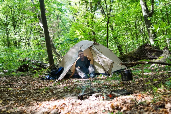 Bir şenlik ateşi ve ormandaki bir turist çadır, çadır turist dinleniyor.