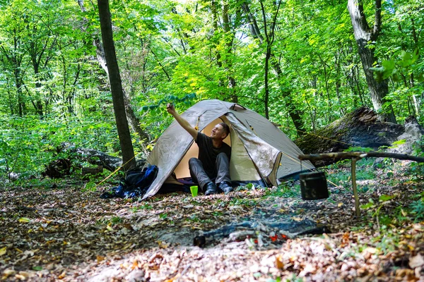 Bir şenlik ateşi ve ormandaki bir turist çadır, çadır turist dinleniyor.
