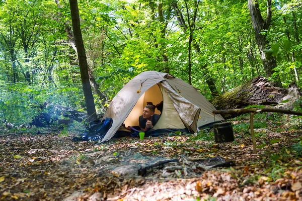 Bir şenlik ateşi ve ormandaki bir turist çadır, çadır turist dinleniyor. — Stok fotoğraf