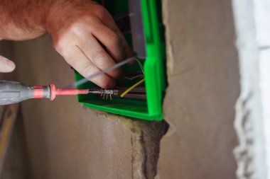 Eller elektrik tesisatı drywall duvarda delik yoluyla çekti.