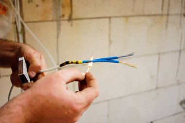 Taşınabilir cihaz test hatası nedeniyle zarar görmüş kablo tutarak elektrikçi. Kötü bir şekilde onarıldı. Kablonun seçici odak