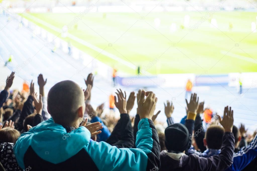 Football fans clapping on the podium of the stadium