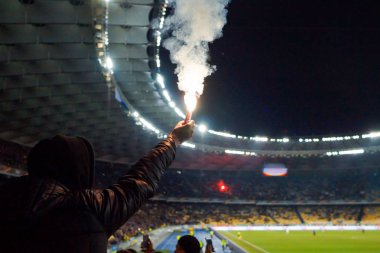 futbol taraftarları bir maç sırasında yangında meşaleler tutan