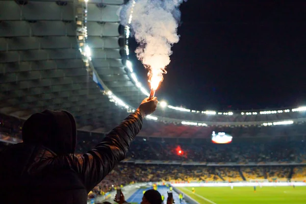 Aficionados al fútbol están sosteniendo antorchas en el fuego durante un partido — Foto de Stock