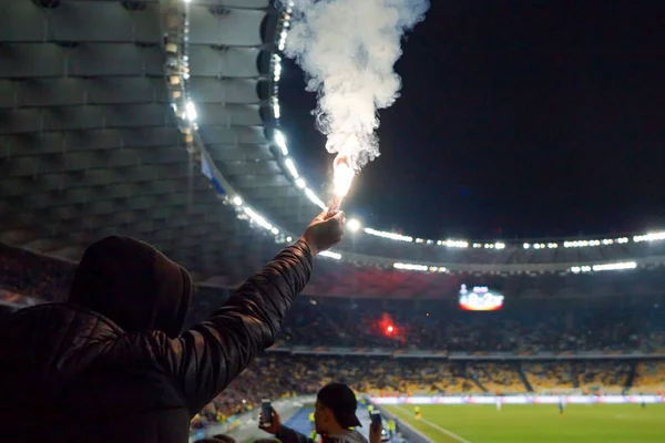 Aficionados al fútbol están sosteniendo antorchas en el fuego durante un partido — Foto de Stock