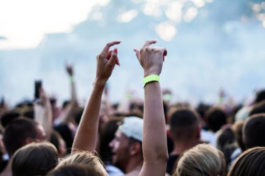 Seyirci bir Müzik Festivali ve sahne yukarıdan aşağı akış ışıklar kaldırdı elleriyle. Yumuşak odak, yüksek ISO, grenli görüntü.