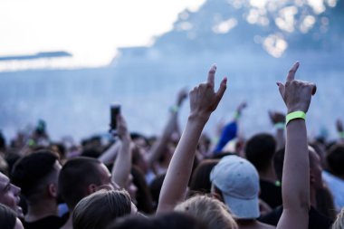 Seyirci bir Müzik Festivali ve sahne yukarıdan aşağı akış ışıklar kaldırdı elleriyle. Yumuşak odak, yüksek ISO, grenli görüntü.