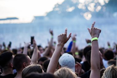 Seyirci bir Müzik Festivali ve sahne yukarıdan aşağı akış ışıklar kaldırdı elleriyle. Yumuşak odak, yüksek ISO, grenli görüntü.