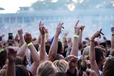 Seyirci bir Müzik Festivali ve sahne yukarıdan aşağı akış ışıklar kaldırdı elleriyle. Yumuşak odak, yüksek ISO, grenli görüntü.