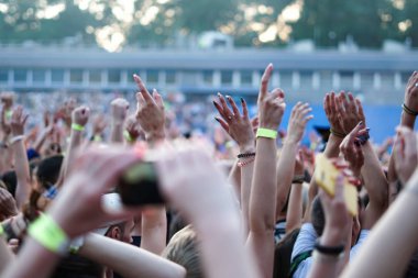 Seyirci bir Müzik Festivali ve sahne yukarıdan aşağı akış ışıklar kaldırdı elleriyle. Yumuşak odak, yüksek ISO, grenli görüntü.