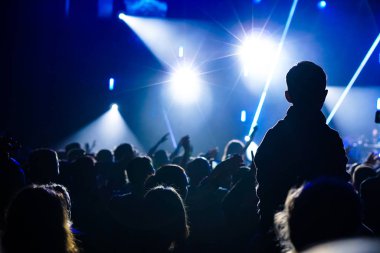 Yaz müzik festivalinde konser sırasında elleri havada dans eden, şarkı söyleyen ve müzik dinleyen kızlar.
