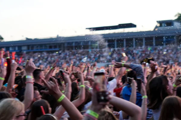 Натовп на музичному концерті, аудиторія піднімає руки вгору — стокове фото