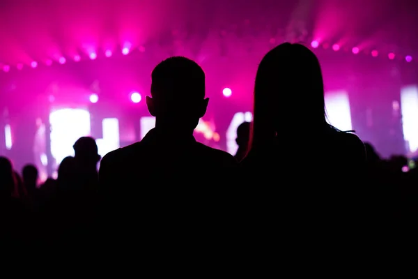 Sylwetki ludzi na koncercie przed sceną w jasnym świetle — Zdjęcie stockowe