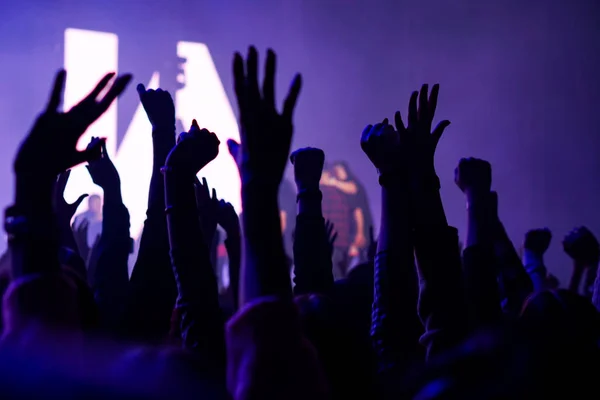 Multitud en un concierto de música, audiencia levantando las manos — Foto de Stock