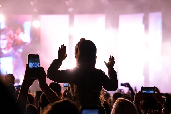 Dziewczyny z podniesionymi rękami tańczą, śpiewają i słuchają muzyki podczas koncertu na letnim festiwalu muzycznym — Zdjęcie stockowe