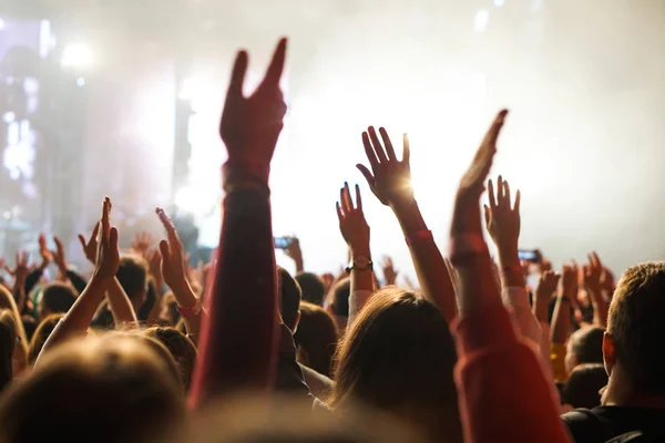 Publiken på en konsert, publiken höjer händerna upp — Stockfoto