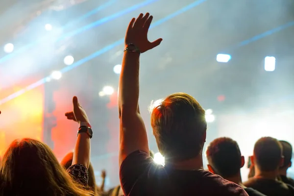 Multidão em um concerto de música, público levantando as mãos — Fotografia de Stock