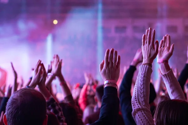 crowd cheering and hands raised at a live music concert