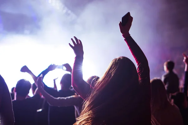 crowd cheering and hands raised at a live music concert