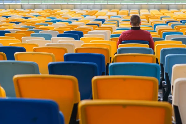 spectators watch football in a half-empty stadium