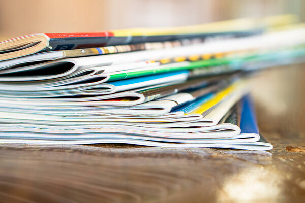 Closeup background of a pile of old magazines with bending pages