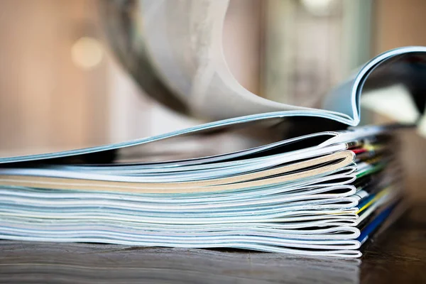 Closeup background of a pile of old magazines with bending pages