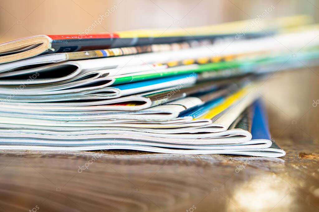 Closeup background of a pile of old magazines with bending pages