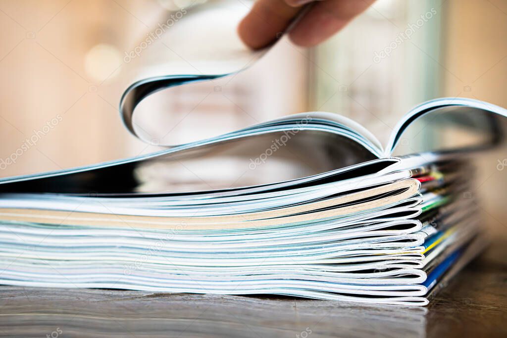 Closeup background of a pile of old magazines with bending pages