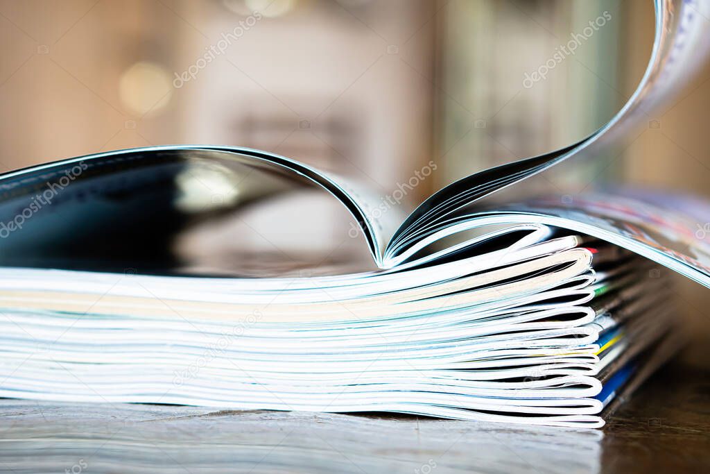 Closeup background of a pile of old magazines with bending pages