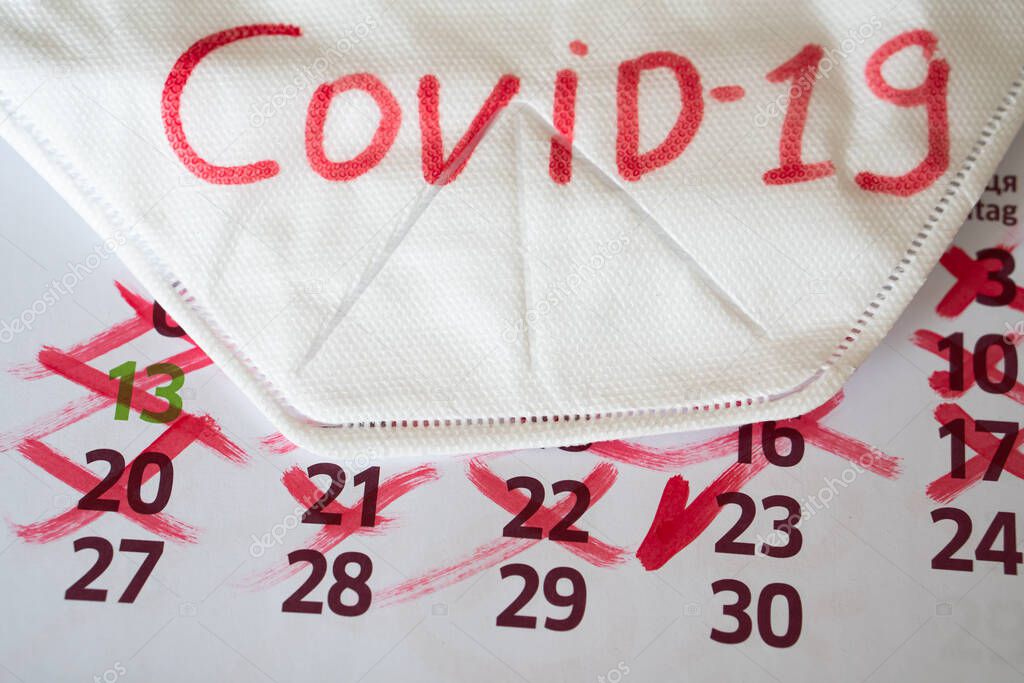 the respirator lies on calendar with marks. Concept of the raging coronavirus pandemic in 2020
