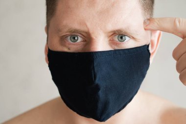 Tıbbi maskeli adam, öfkeli duyguların portresi..