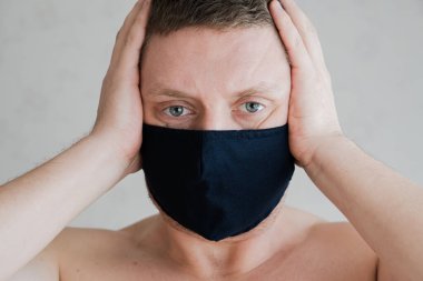 Tıbbi maskeli adam, öfkeli duyguların portresi..