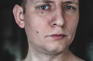 Gri tonlu genç bir adamın portresi. Yakın plan, düşünceli duygular.