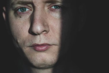 Gri tonlu genç bir adamın portresi. Yakın plan, düşünceli duygular.