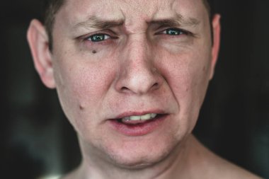 Gri tonlu genç bir adamın portresi. Yakın plan, düşünceli duygular.