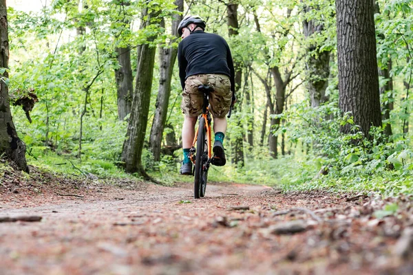 Ung Man Från Ryggen Rider Cykel Längs Stigen Bland Träden — Stockfoto