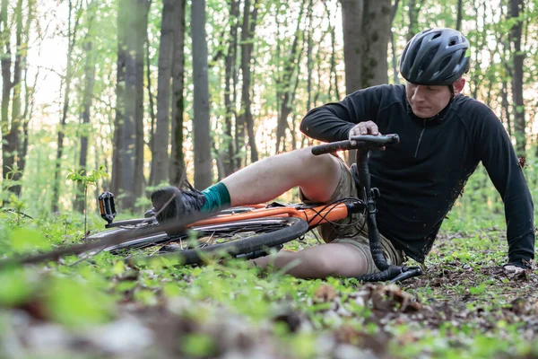 一个年轻人在森林里骑自行车摔倒了 受了伤 — 图库照片