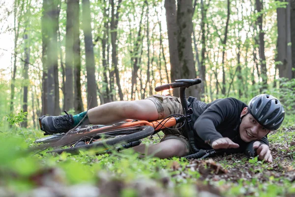 a young guy fell on a bicycle in the forest, was injured